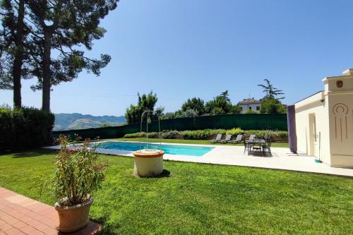 un patio trasero con piscina y una casa en Villa Fazia, en Ortezzano