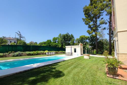un patio trasero con piscina y césped en Villa Fazia, en Ortezzano