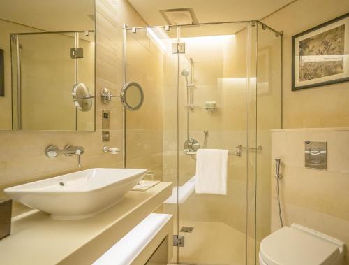 a bathroom with a sink and a glass shower at HomesGetaway-Lavish STU in Hyatt Regency Creek Heights Residences in Dubai