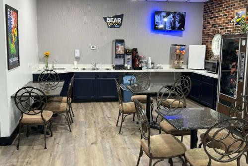 a restaurant with tables and chairs and a counter at Travelodge by Wyndham Airport Platte City in Platte City