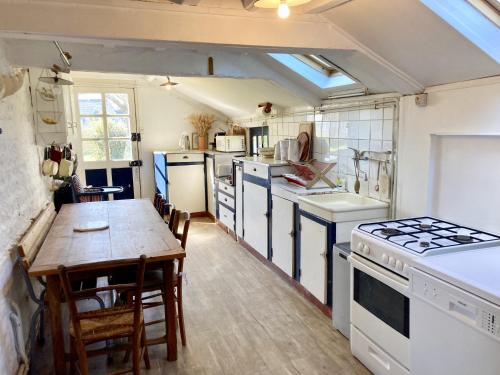 une cuisine avec une table et une cuisinière four supérieur dans l'établissement Vieux Logis, à Varengeville-sur-Mer