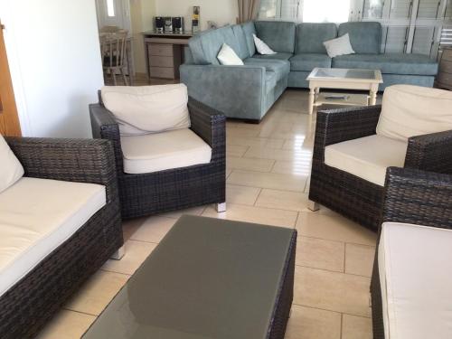 ein Wohnzimmer mit Korbstühlen und einem Sofa in der Unterkunft Villa Garmar CTO Approved 4487 in Paralimni