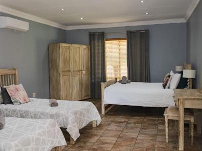 a bedroom with two beds and a window at Buffalo Ranch Game Lodge in Groblersdal