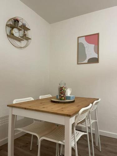 une table en bois avec des chaises et une plaque de cuisson. dans l'établissement Appartement Cosy à Cenon, proche transports, à Cenon