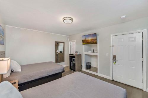 a small bedroom with a bed and a door at Rodeway Inn Stockton Highway 99 in Stockton