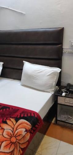 a bedroom with a bed with a pillow and a table at Hotel Pratap Regal,Bharatpur in Bharatpur