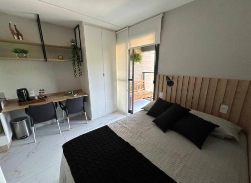 um quarto com uma cama, uma secretária e uma cozinha em Studio novo, perto Allianz Park, ao lado do metrô em São Paulo