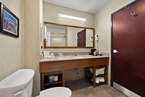 a bathroom with a sink and a toilet and a mirror at Comfort Inn & Suites Airport Convention Center in Reno