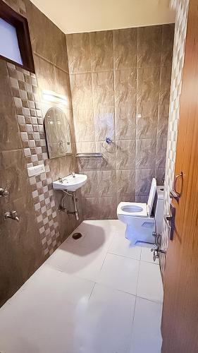 a bathroom with a toilet and a sink at Govind puri residency in New Delhi