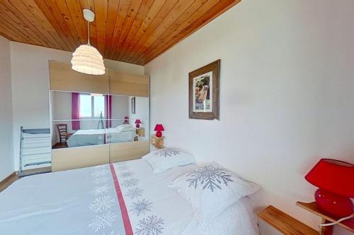 um quarto com uma cama branca e um espelho em CASA-Isabelle near the lake em Embrun