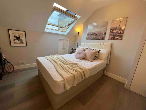 a bedroom with a large bed with a skylight at Amazing Location apartment in Maida Vale in London