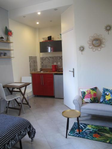 un salon avec un canapé et une table et une cuisine dans l'établissement Studio avec cour extérieure aux portes de Paris, à Bagnolet