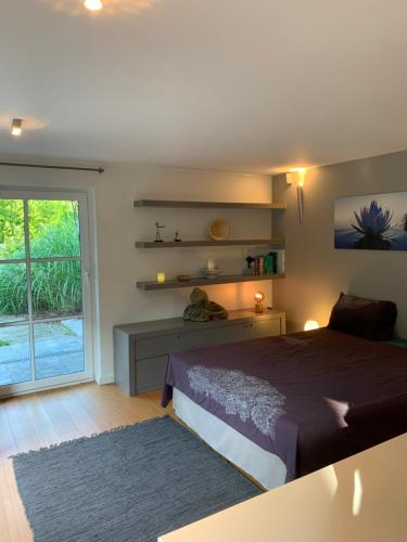 ein Schlafzimmer mit einem Bett und einem großen Fenster in der Unterkunft Le Jardin d'Isa in Chaumont-Gistoux
