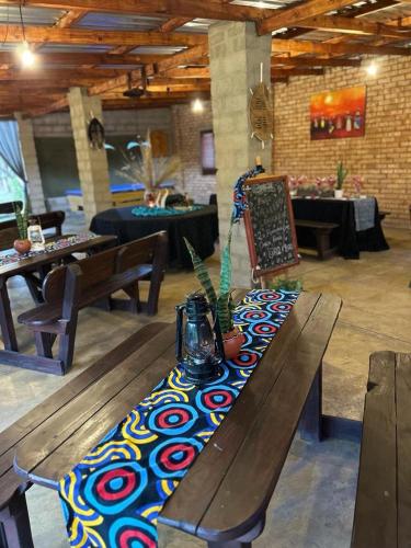 a wooden bench with a table in a room at Buffalo Ranch Game Lodge in Groblersdal