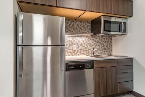 a kitchen with a stainless steel refrigerator and a sink at MainStay Suites Milwaukee-Franklin in Franklin