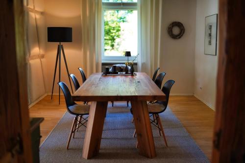 - une table en bois dans une chambre entourée de chaises dans l'établissement Bergschlössl Herrenwies, à Forbach