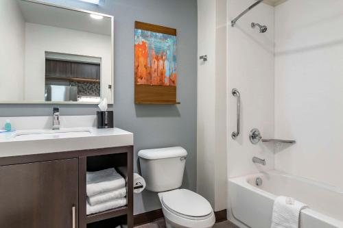a bathroom with a sink and a toilet and a tub at MainStay Suites Milwaukee-Franklin in Franklin