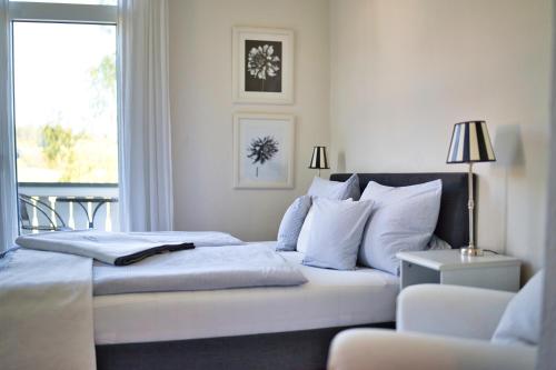 a bedroom with a bed with white pillows and a window at Bergschlössl Herrenwies in Forbach