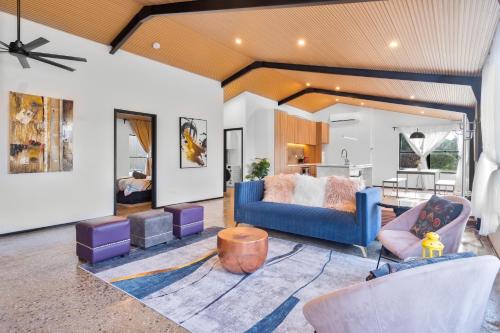 a living room with a blue couch and chairs at Shed House Lux Farm Stay in Buninyong