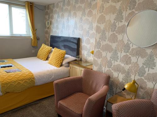 a bedroom with a bed and a chair and a mirror at The Fylde International Guest House in Blackpool