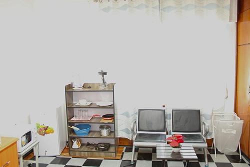 a kitchen with two chairs and a shelf with dishes at Kind private room 8 in Addis Ababa