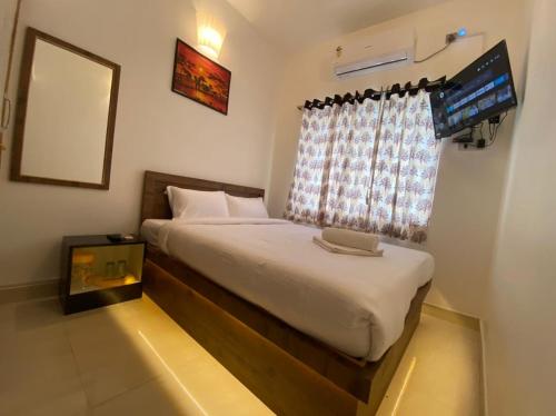 a bedroom with a bed with a laptop on it at Le Poshe Luxury Pondicherry in Puducherry