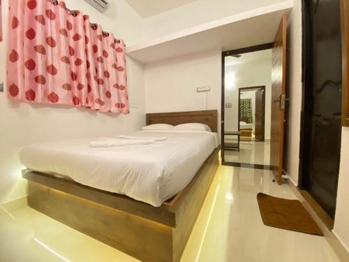 a bedroom with a bed and a red curtain at Le Poshe Luxury - TIE Hotels & Resorts in Puducherry