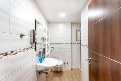 a white bathroom with a sink and a toilet at Aspire Castillo Reutlingen, Trademark Collection by Wyndham in Reutlingen
