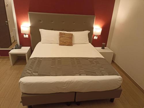 a bedroom with a large bed with two tables at Palazzo Marignano Hotel in Melegnano