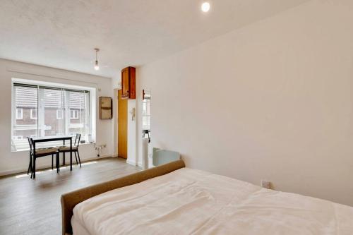 1 dormitorio con cama, mesa y ventana en Remarkable 1-Bed Studio in Hayes en Hayes