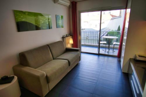 d'un salon avec un canapé et un balcon. dans l'établissement Ref NAR - Palmes dProperties, à Cannes