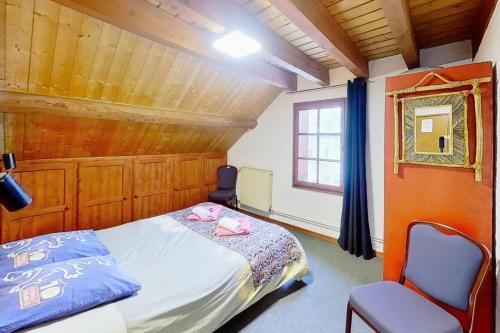 una camera con un letto e una sedia e una finestra di CASA-Le Gerland pretty duplex in a chalet St-Véran 7p a Saint-Véran
