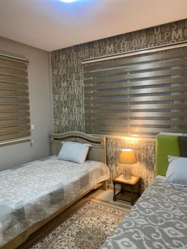 1 dormitorio con 2 camas individuales y ventana en Superbe appartement hautstanding en Sfax