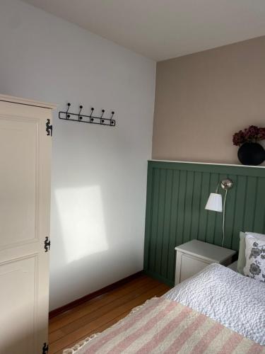 a bedroom with a bed and a green wall at Kajüthus Apartment 2 in Fehmarn