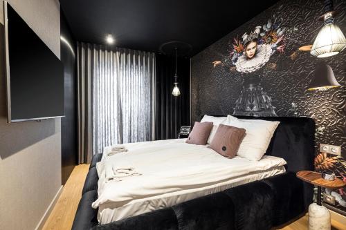 a bedroom with a bed with a painting on the wall at Rent like home - Apartament w Deo Plaza in Gdańsk