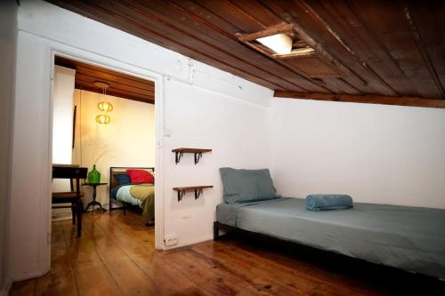 a bedroom with two beds and a room with a desk at Casa Pássaro in Vila Franca de Xira