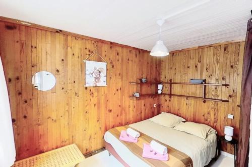 um quarto com uma cama e uma parede de madeira em CASA-Le Toussiard apartment in chalet St-Véran 4-6p 