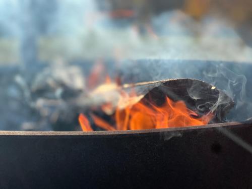 uma fogueira numa grelha com chamas e fumo em Gîte du coucher de soleil em Lavans-Vuillafans