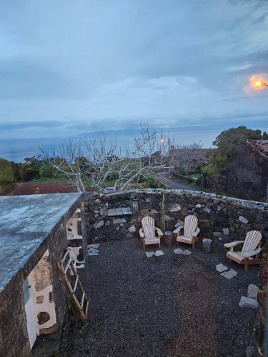 a group of chairs sitting on top of a stone wall at Waka Sun Rise Pico Azores in Cais do Pico