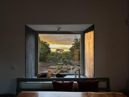 a large window in a room with a table and a view at Waka Sun Rise Pico Azores in Cais do Pico