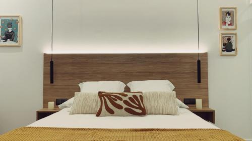 Schlafzimmer mit einem Bett mit einem Kopfteil aus Holz in der Unterkunft The Park House II by homebilbao. in Bilbao