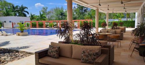 a patio with tables and chairs and a pool at Hotel Morúa in Yopal