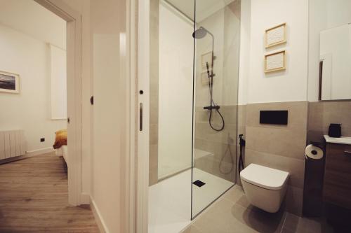 a bathroom with a toilet and a glass shower at The Park House II by homebilbao. in Bilbao