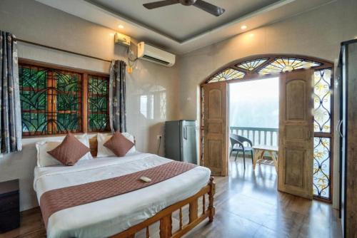 a bedroom with a bed and a window with a view at Calangute Beach Steps in Calangute