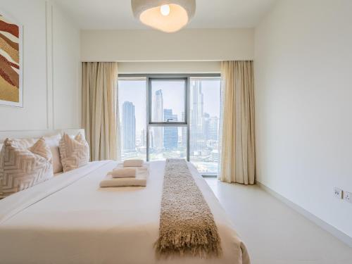 a bedroom with a large bed with a large window at Exquisite 2BR w/ Breathtaking Burj Khalifa Skyline in Dubai