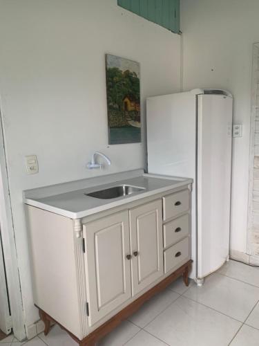 a kitchen with a sink and a refrigerator at Casa do paraiso in Palhoça