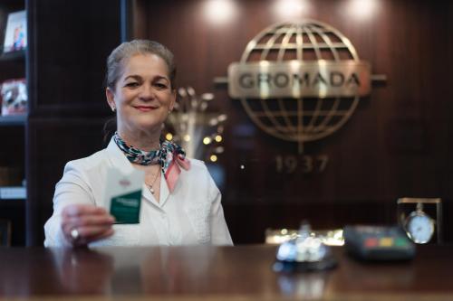 a woman sitting at a table in a bar at Hotel Gromada Toruń in Toruń