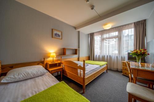 a hotel room with two beds and a television at Hotel Gromada Zakopane in Zakopane