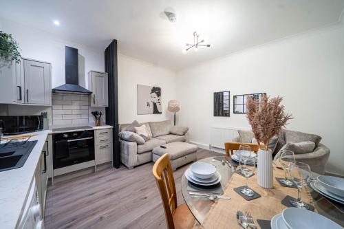 a kitchen and a living room with a table in a kitchen at Charming 1-Bedroom Just 1 Mile from Morley Town Center in Leeds in Pudsey