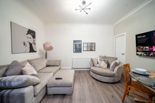 uma sala de estar com um sofá e duas cadeiras e uma mesa em Charming 1-Bedroom Just 1 Mile from Morley Town Center in Leeds em Pudsey